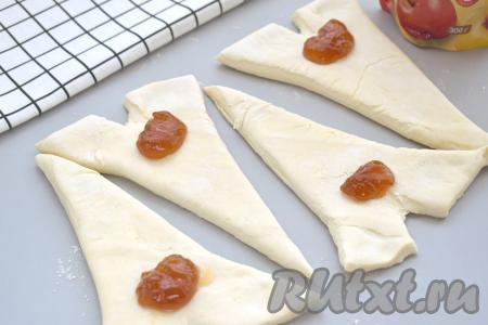 Возле надреза, отступив от краёв теста по 1 сантиметру, выкладываем 1 чайную ложку повидла.