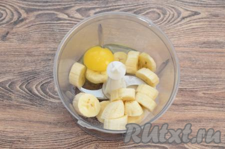 В чашу измельчителя выложить нарезанный на кусочки банан, вбить сырое яйцо, всыпать сахар. Я взяла достаточно сладкий банан, поэтому добавила в тесто всего 1 столовую ложку сахара. Если вы возьмёте не очень сладкий банан, тогда добавьте в общей сложности 1,5 столовых ложки сахара.