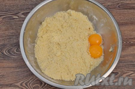 Масло с сухими ингредиентами перетереть руками до получения мелкой, однородной песочной крошки. В миску с песочной крошкой выложить желтки.