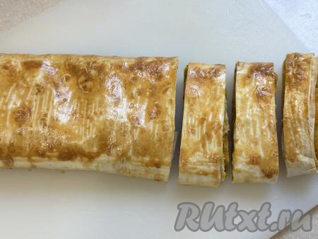 Противень с рулетом с тыквой поставить в духовку, разогретую до 180 градусов, запекать минут 30-35 (до подрумянивания лаваша). Готовую выпечку достать из духовки, дать немного остыть, после этого переложить на разделочную доску, нарезать на кусочки. 