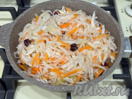 Пока обжаривается мясо курицы, нужно квашеную капусту выложить в дуршлаг, промыть водой, чтобы избавиться от лишней кислотности и сделать вкус более мягким. Отжать капусту от лишней влаги. К обжаренному куриному мясу выложить подготовленную квашеную капусту. 