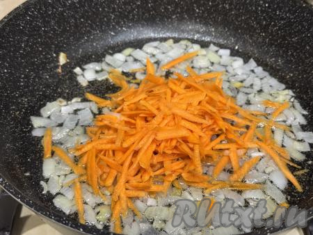 Обжарить лук в течение 3-4 минут (до прозрачности), периодически помешивая, на среднем огне. К обжаренному луку добавить натёртую на крупной тёрке морковку, перемешать, немного подсолить овощи.