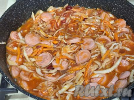 Перемешать капусту с сосисками и томатным соусом. Дать соусу закипеть, уменьшить огонь, тушить квашеную капусту с сосисками под крышкой в течение 25 минут (до мягкости капусты), периодически перемешивая.