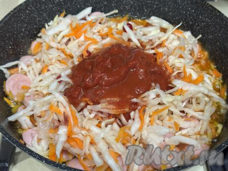 В сковороду с морковкой, луком и сосисками добавить квашеную капусту, влить получившийся томатный соус.