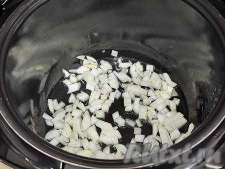 В чашу мультиварки влить растительное масло, выставить режим "Жарка" на 10 минут, выложить мелко нарезанный лук.