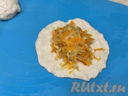 Начинку зрительно разделить на 10 равных частей. В центр теста, растянутого в круг, выложить одну часть начинки из жареной квашеной капусты. 