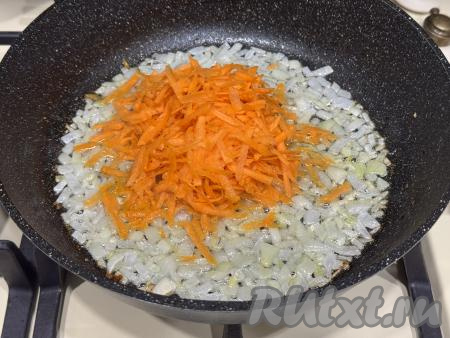 К луку, обжаренному до прозрачности, выложить натёртую на крупной тёрке морковку, перемешать овощи. 