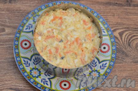 Подавать этот салат можно в салатнике. А я решила выложить рыбный салат в кулинарное кольцо, предварительно поставив его на плоскую тарелку. Поставить тарелку с кольцом с салатом в холодильник минут на 30, чтобы блюдо немного охладилось.