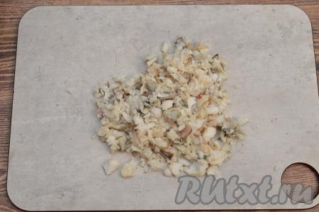Остывшие кусочки минтая отделить от костей и кожи. Получившееся филе минтая нарезать достаточно мелко.