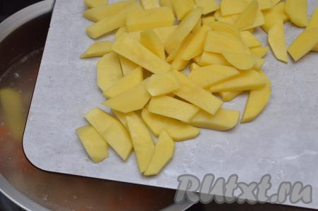 Сразу же выложить в кастрюлю и очищенный картофель, нарезанный на средние брусочки.