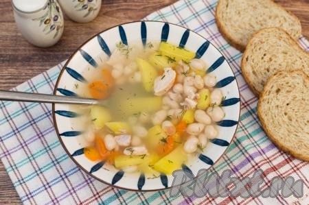 Аппетитный, насыщенный, очень вкусный суп, сваренный из белой сухой фасоли с курицей, разлить по тарелкам. Добавить в каждую тарелку, по желанию, зелень. Подать фасолевый суп в горячем виде к столу. 