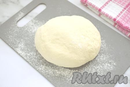 Перемешиваем содержимое миски вначале лопаткой (или столовой ложкой). А после того как дрожжевое тесто начнёт собираться в ком, продолжаем замешивать его руками. Вымешиваем тесто руками не менее 7 минут. В итоге замешанное тесто должно получиться мягким, эластичным, не липнущим к ладоням. Если тесто будет липнуть к рукам, тогда добавьте совсем немного муки и хорошо вмешайте её. Миску с замешанным дрожжевым тестом накрываем полотенцем и оставляем в тёплом месте на 45 минут (тесто должно хорошо подняться, увеличившись в объёме, как минимум, в 2 раза).