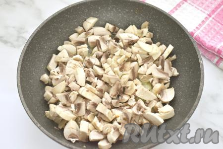 К обжаренному луку выкладываем шампиньоны (или отваренные лесные грибы), нарезанные некрупно, перемешиваем. Обжариваем грибы с луком, время от времени перемешивая, до испарения влаги (примерно 7-10 минут). В процессе обжаривания солим грибы по вкусу. Жареные грибы убираем с огня, даём немного остыть.