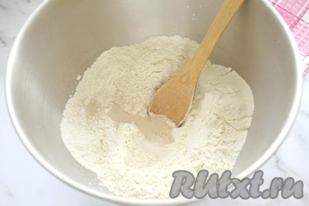 Прежде всего замесим дрожжевое тесто для осетинского пирога. Для этого в глубокую миску просеиваем муку, всыпаем сахар, соль, сухие дрожжи, перемешиваем, образуя в центре воронку.