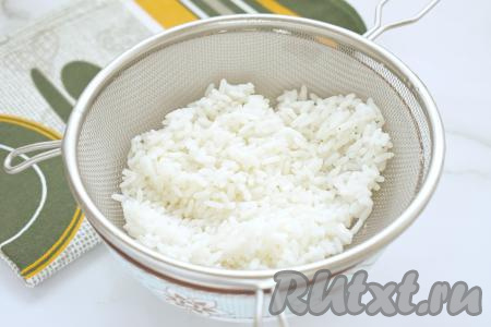 Рис выкладываем в сито, промываем проточной водой, кладём в кастрюлю с кипящей водой, перемешиваем, снова даём закипеть и отвариваем до готовности (в течение минут 20 с момента закипания воды). Сварившийся рис откидываем на сито, оставляем на несколько минут, чтобы стекла вода и рис остыл.