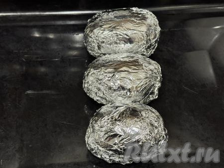 Картошины, плотно завёрнутые в фольгу, выложить в форму для запекания (или на противень) и отправить в духовку, разогретую до 200 градусов, на 40-45 минут (запекать до готовности). Для того чтобы проверить готовность картофеля, нужно прямо сквозь фольгу проколоть картошку зубочисткой, если зубочистка входит легко, значит картофель готов и нужно доставать его из духовки. 