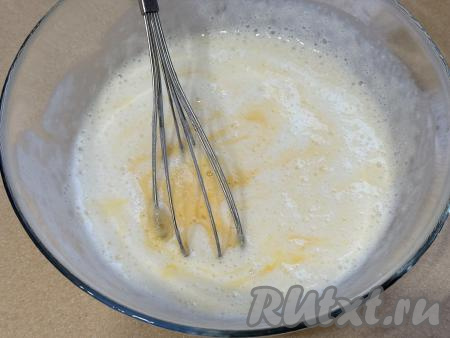 В процессе гашения соды в миске на поверхности кефира появятся пузырьки, смесь немного увеличится в объёме. В миску со смесью кефира и соды добавить соль, сахар, 1 сырое яйцо, перемешать смесь венчиком. 