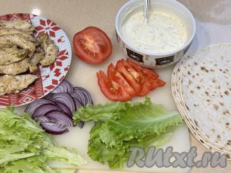 Готовую курицу переложить на тарелку, дать немного остыть. Лук (у меня - красный лук) почистить, нарезать на тонкие полукольца. Помидор вымыть, нарезать на дольки. Листья салата помыть и обсушить.