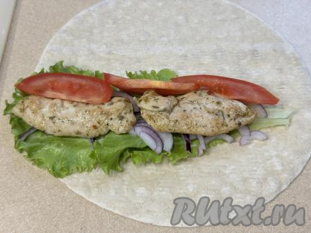 На курицу (или рядом с ней) выложить 2-3 дольки помидора.