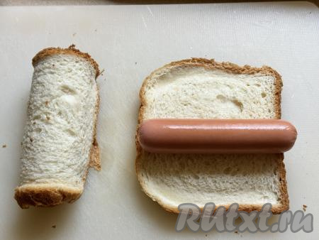 Выложить сосиску на кусок подготовленного тостового хлеба.