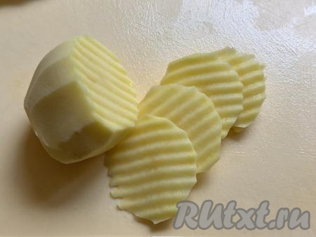 Картошку почистить, нарезать на тонкие кружочки (ориентировочно толщиной 2-3 миллиметра). Я нарезала картофель рифлёным ножом. Желательно, чтобы все кружочки  были примерно одинаковой толщины, чтобы они равномерно запеклись в аэрогриле.