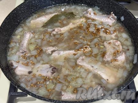 Перемешать гречку с рёбрами, довести бульон до кипения, уменьшить огонь до минимума. Закрыть сковороду крышкой, готовить минут 20-25 (до полного впитывания воды). 