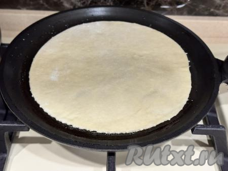 Хорошо разогреть сухую сковороду, уменьшить огонь до среднего. Выложить одну лепёшку на сковороду. 