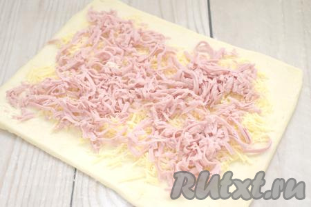 Колбасу тоже натираем на крупной тёрке. Выкладываем натёртую колбасу поверх слоя сыра.