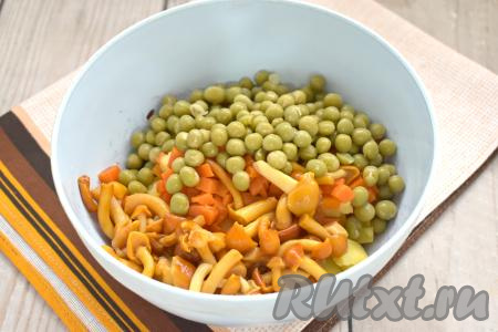 Маринованные опята выкладываем в дуршлаг, ополаскиваем холодной водой, лишней воде даём стечь. В салатник с овощами добавляем маринованные опята и консервированный горошек без жидкости.