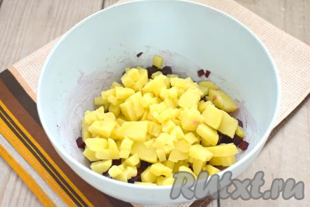 Варёную картошку очищаем, тоже нарезаем на маленькие кубики, выкладываем в салатник со свеклой. Желательно чтобы овощи нарезались на кубики примерно одинакового размера, тогда винегрет будет особенно аппетитным и вкусным. 