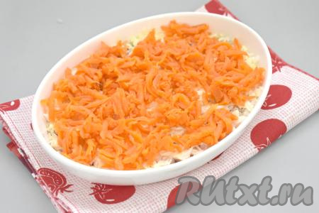 Следующим слом равномерно раскладываем морковку, натёртую на крупной тёрке.