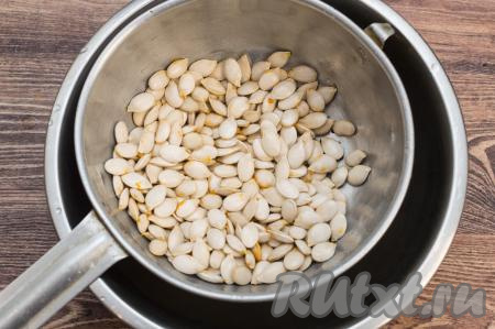 Но я, для того чтобы тщательно промыть семечки, выкладываю их в дуршлаг и тщательно мою под проточной водой, слегка перетирая их пальцами. В процессе мытья семечек я убираю оставшиеся волокна тыквы, смываю покрывающую их плёночку. Промытые семечки оставляю на несколько минут в дуршлаге, чтобы стекла лишняя вода.