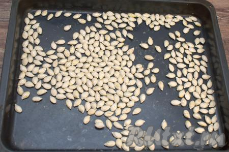 Отправить противень с тыквенными семечками ещё на 10 минут в духовку. Затем достать их и попробовать на готовность. Готовые семечки должны обладать вкусом уже подсушенных (как бы жареных) семечек, но сами ядрышки будут совсем слегка влажными. После остывания эта влажность уйдёт. Если семечки недостаточно подсушились, их нужно отправить в духовку минут на 10, в течение этого времени их каждые 2-3 минуты нужно будет доставать, перемешивать и проверять на готовность, чтобы семечки не пересушились. Мне всего потребовалось подсушивать семечки в течение 38 минут.