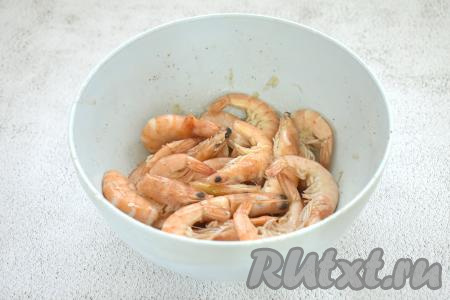 Перемешиваем креветки, равномерно покрывая их чесноком, лимонным соком, маслом и специями. Оставляем их постоять при комнатной температуре на 15-20 минут, чтобы креветки замариновались.