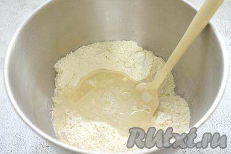 В получившееся углубление в смеси муки и дрожжей вливаем тёплую воду (температура воды должна быть ориентировочно 38-39 градусов, если вода будет выше 42 градусов, дрожжи могут погибнуть) и растительное масла.