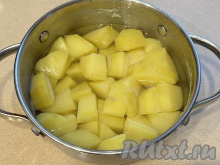 После закипания воды, уменьшив огонь, отварить картофель до готовности (обычно на варку картофеля требуется минут 20-25, полностью готовая картошка должна стать достаточно мягкой, легко прокалываться ножом). Убрать кастрюлю со сварившимся картофелем с огня. Слить из кастрюли воду, в которой варился картофель. 