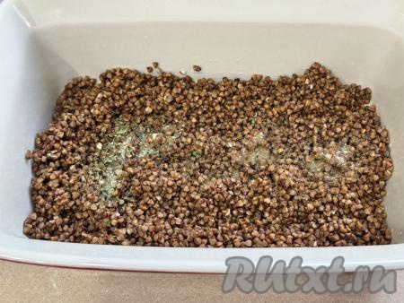 В жаропрочную форму выложить подготовленную гречку, посолить по вкусу, перемешать, равномерно распределяя крупу по дну формы. 