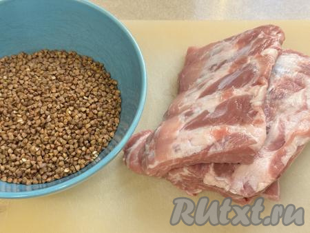 Подготовить продукты для приготовления свиных рёбрышек с гречкой в духовке. Свиные рёбра промыть водой, обсушить. Гречку, если нужно, перебрать, после этого выложить в сито и очень хорошо промыть под проточной водой, лишней воде дать стечь. 