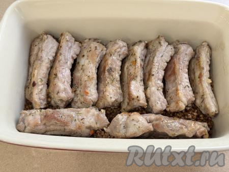 Выложить обжаренные свиные рёбрышки поверх гречки. 