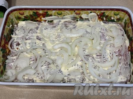 Лук нарезать на полукольца, разложить поверх индейки, смазанной майонезом. 