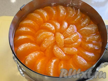 Залить все дольки мандарина остывшим желе и поставить в холодильник на ночь (до полного застывания мандаринового слоя чизкейка). 