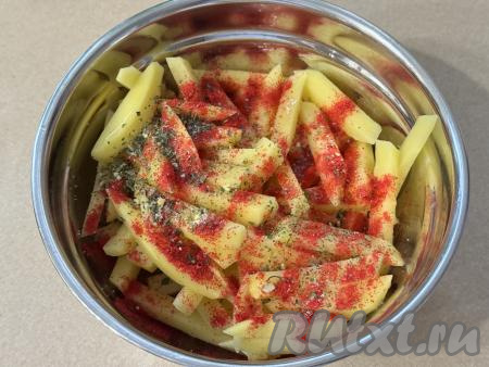 Переложить картофельные брусочки в миску, добавить растительное масло, соль и специи (я в качестве специй использовала паприку и соль, смешанную со специями).
