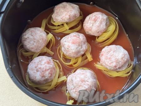 Влить соус в чашу аэрогриля с гнёздами из макарон и фаршем. Соус должен практически полностью покрывать макаронные гнёзда.