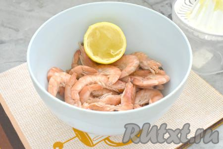 Размороженные креветки перекладываем в миску, вливаем к ним 2 столовых ложки сока, выжатого из лимона.