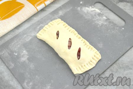 Накрыть начинку стороной теста с надрезами. Скрепить края, прижимая их вилкой. Если вилка пристаёт к тесту, тогда можно периодически кончики вилки окунать в муку.