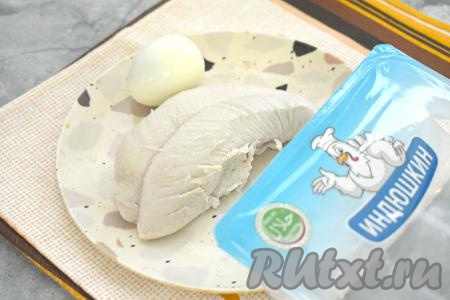 Прежде всего займёмся начинкой для блинов. Для этого филе индейки моем, выкладываем в кастрюлю, заливаем полностью водой, ставим на огонь, после закипания подсаливаем воду и варим мясо на небольшом огне минут 35-40 (до готовности индейки). Варёному мясу даём остыть. В отдельной кастрюле отвариваем 1 яйцо в течение 10 минут с момента закипания воды. Варёное яйцо заливаем холодной водой, даём остыть, после этого очищаем.