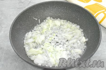 Лук очищаем, нарезаем на маленькие кусочки, выкладываем в сковороду, в которой уже прогрелось растительное масло. Обжариваем лук до прозрачности (в течение 3-4 минут), иногда помешивая, на среднем огне. Убираем с огня, даём немного остыть.
