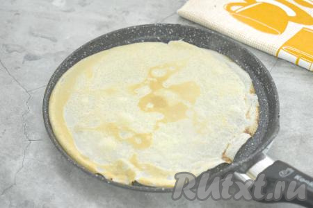 Поверхность сковороды смазываем растительным маслом, хорошо разогреваем, затем вливаем небольшой половник теста. Сразу равномерно распределяем блинное тесто по дну сковороды. Жарим блин на среднем огне до подрумянивания с двух сторон (ориентировочно по 1 минуте с каждой стороны). Готовый блинчик перекладываем со сковороды на тарелку. Перемешивая тесто перед жаркой очередного блина и смазывая сковороду по мере необходимости, постепенно жарим все тонкие, эластичные блинчики, складывая их стопочкой на тарелку. Из предложенного количества ингредиентов я пожарила 12 блинов.