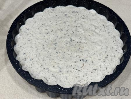 Форму для выпечки диаметром 24-26 сантиметров немного смазать растительным маслом, выложить тесто, разровнять.