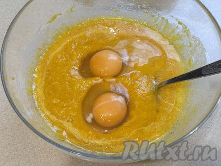 В миску с тыквенно-яблочным пюре влить растительное масло, вбить сырые яйца, тщательно перемешать.